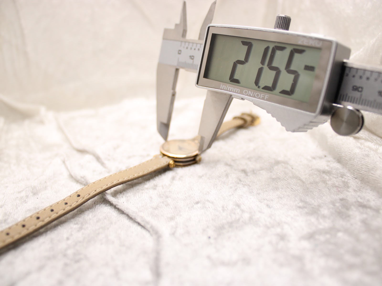 Digital caliper measuring the case diameter of the Gucci 2000L watch, displaying 21.55 mm.