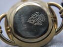 Close-up of the gold-tone case back of the Gucci watch, clearly showing the reference "6000.2 L" and the Gucci crest engraving.