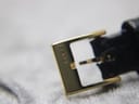 Close-up of the gold-tone buckle, clearly engraved with the "GUCCI" brand name.