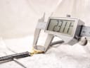 Digital caliper measuring the Gucci watch case diameter at 23.11 mm, showing the precise size of the gold-tone case.