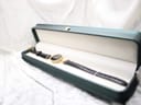 The Gucci 6000.2 L watch presented within a dark green display box, highlighting its elegant presentation.