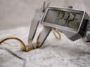 Digital caliper measuring the case width of the Gucci 1500L watch, displaying 12.32 mm.