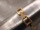 Close-up of the gold-plated Gucci bangle clasp on a wrist sizing mandrel, indicating a size of 160mm.
