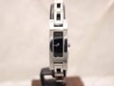 Front view of the Gucci 3900L women's watch on a stand, showing its black rectangular dial and stainless steel bracelet.