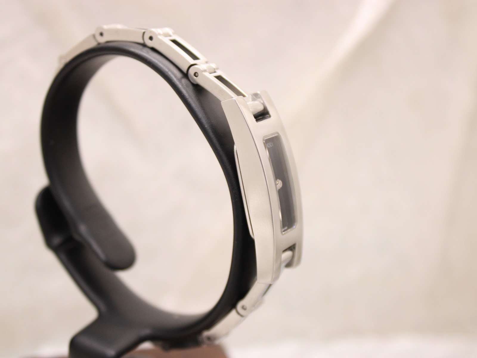 Three-quarter view of the Gucci 3900L watch on a stand, showcasing the curvature of the bracelet.