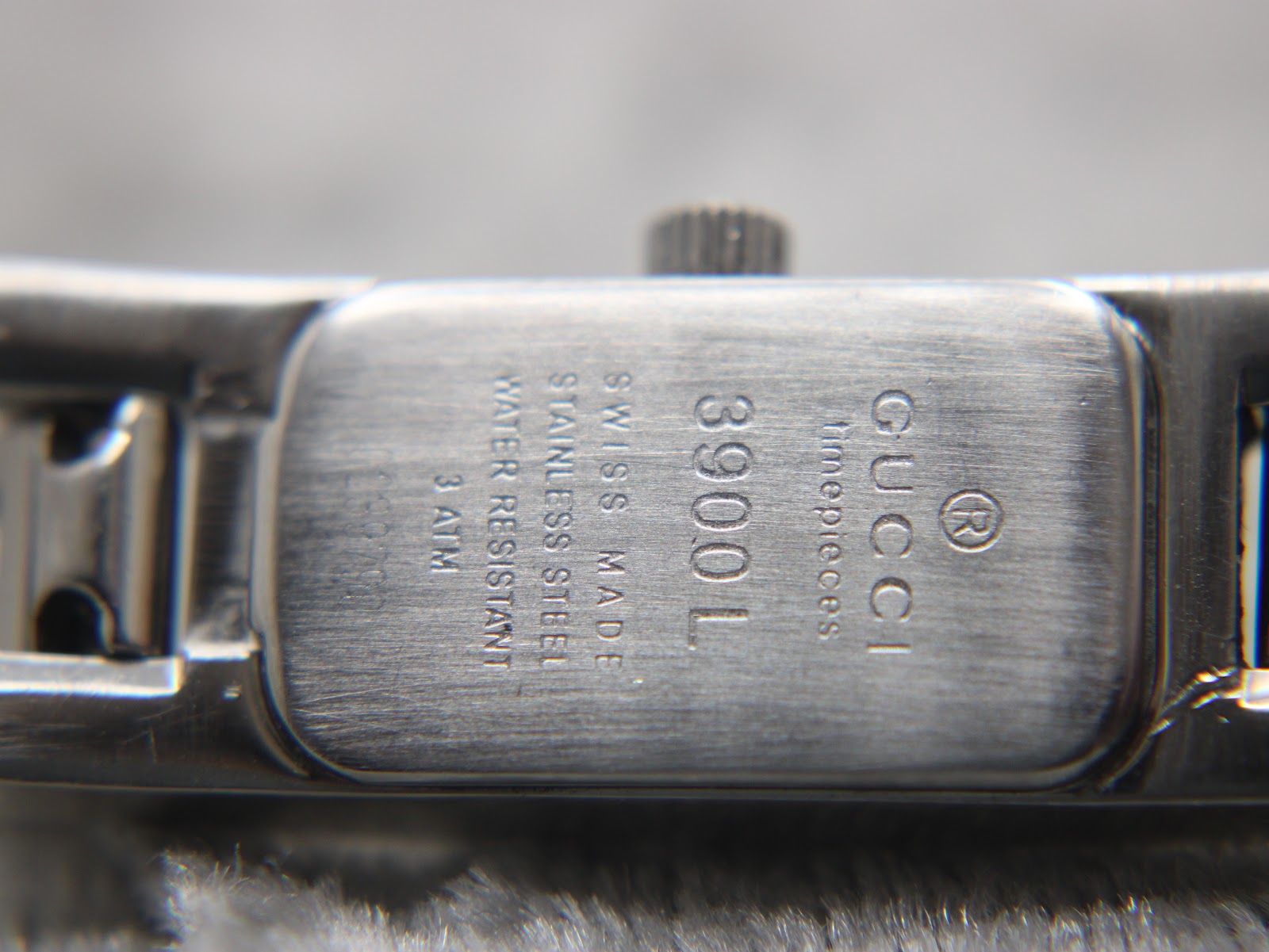 Close-up of the case back engraving, showing "GUCCI timepieces", "3900L", "SWISS MADE", "STAINLESS STEEL", "WATER RESISTANT 3 ATM".