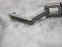 Close-up of the hidden butterfly clasp, showing "STAINLESS STEEL" engraving.