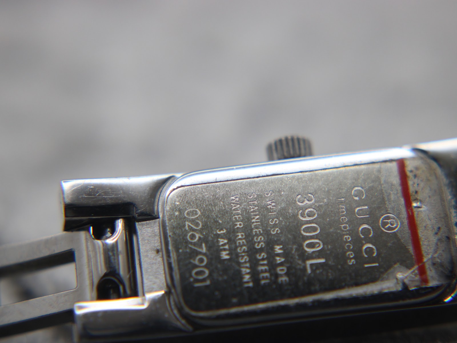 Close-up of the case back engraving, showing 'Gucci', '3900L', 'Swiss Made', 'Stainless Steel', 'Water Resistant 3 ATM', and serial number.