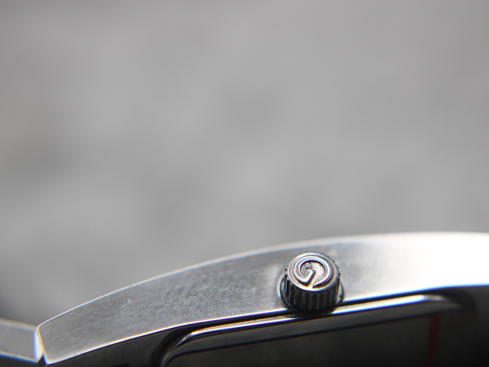 Close-up of the original signed Gucci crown with the intertwined 'G' logo.