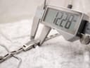 Digital caliper measuring the case width of the Gucci 3900L, displaying 12.28mm.