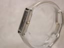 Side view of the Gucci 1500L watch case and crown on a clear stand.