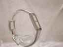 Another side-angle view of the Gucci 1500L watch on a clear display stand, showing the curvature of the bangle bracelet.