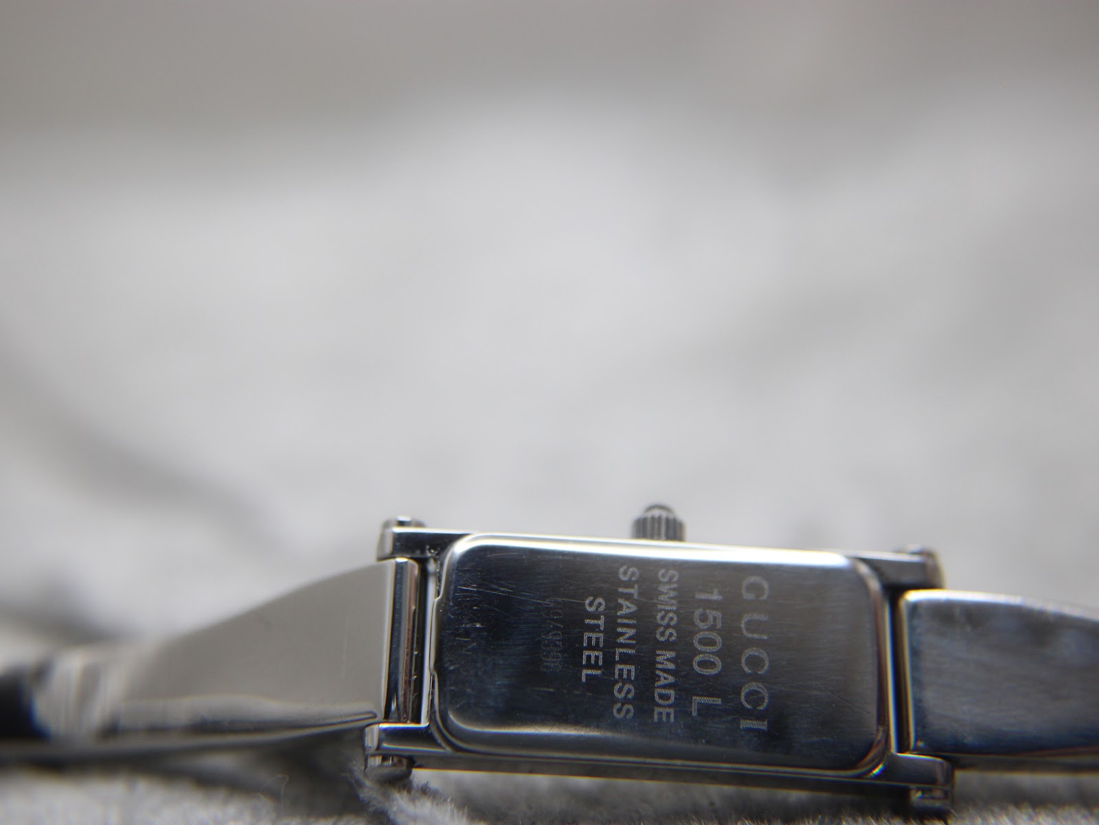 Close-up of the case back of the Gucci 1500L, engraved with "GUCCI 1500 L SWISS MADE STAINLESS STEEL 0949396".