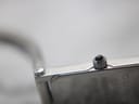 Extreme close-up of the crown with its black cabochon detail and part of the engraved case back.