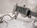 A digital caliper measuring the width of the Gucci 1500L watch case, displaying "12.24 mm".