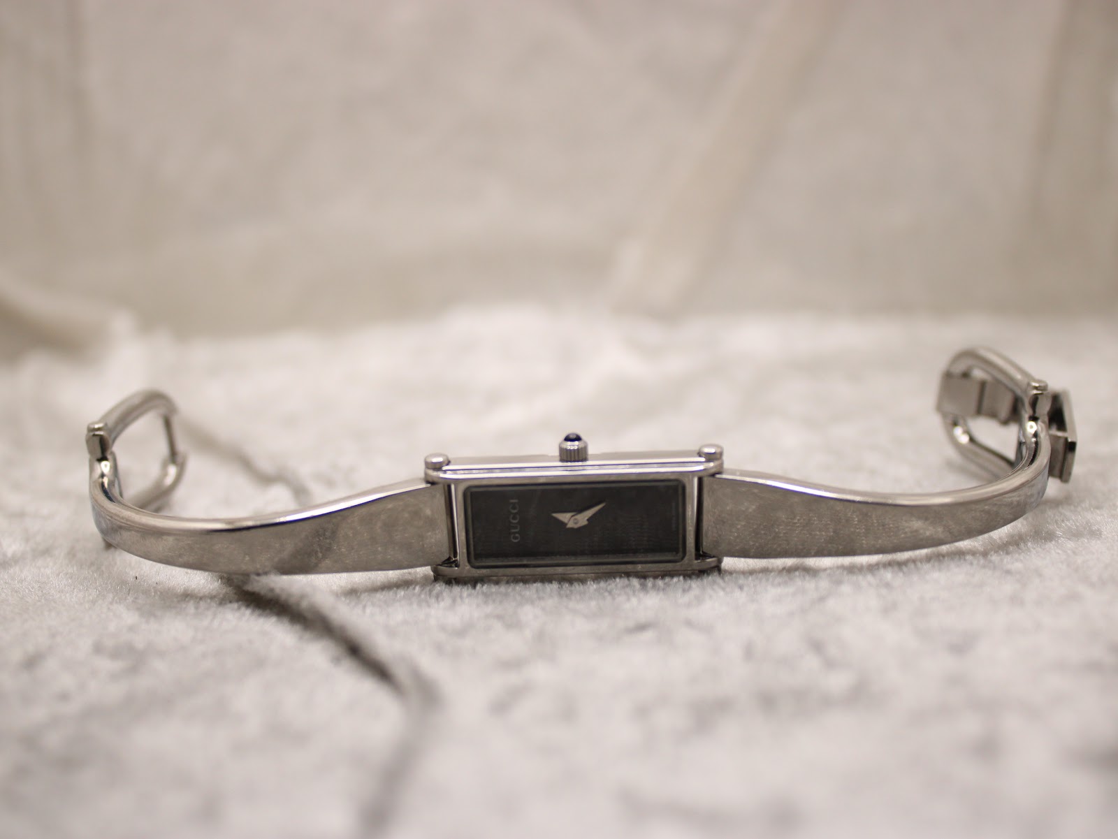 Full view of the Gucci 1500L watch with its integrated stainless steel bracelet laid flat, showing the deployant clasp open.