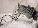 Digital caliper measuring the width of the Gucci 1500L watch case, displaying a reading of 12.23mm.