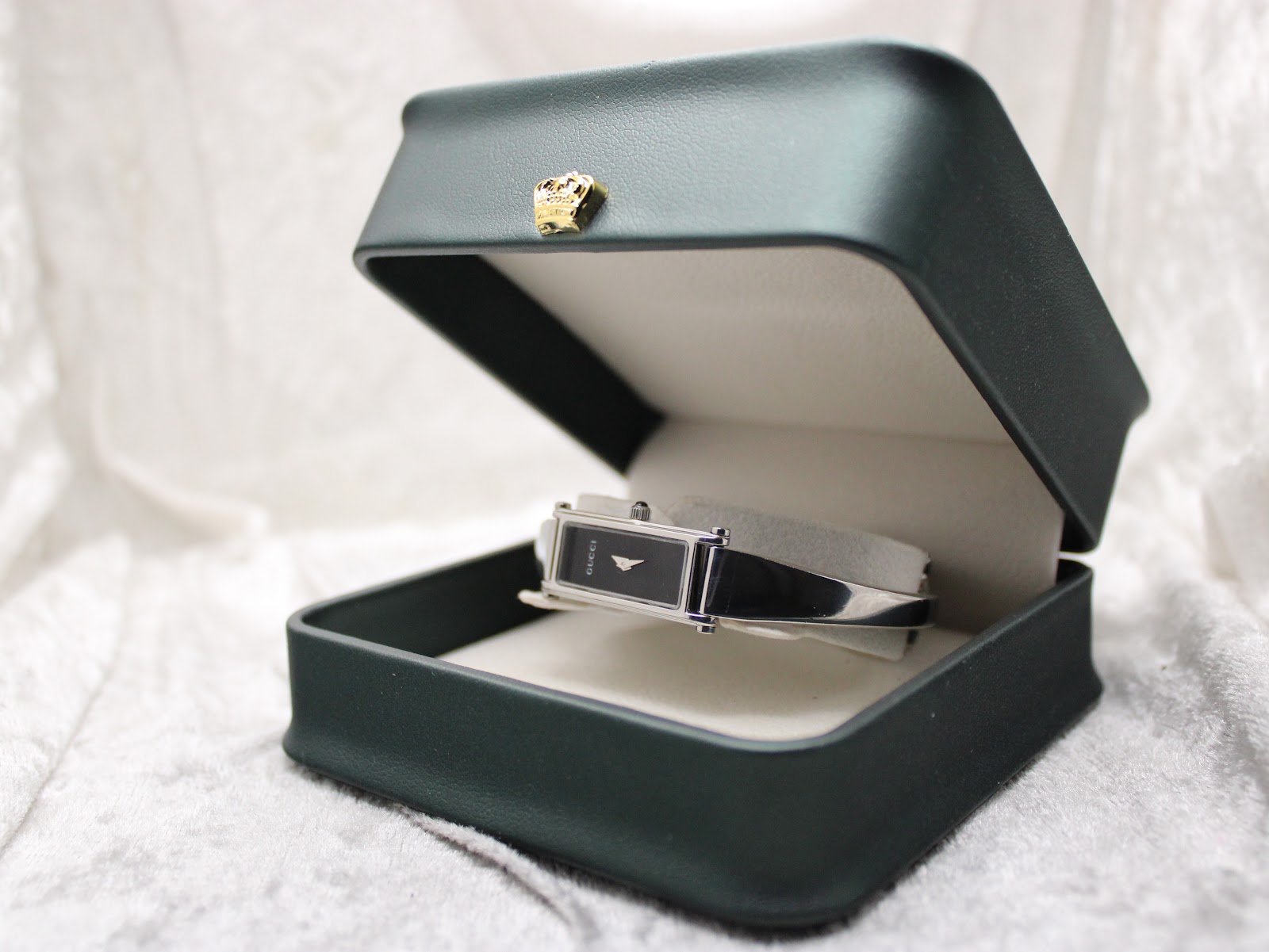 Gucci 1500L watch resting inside a dark green presentation box with a cream interior.