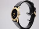 Right-side view of the gold-plated Gucci 3000 Jr watch on a display stand, showing the slim profile and crown.