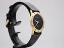 Left-side view of the gold-plated Gucci 3000 Jr watch on a display stand, highlighting the case profile.