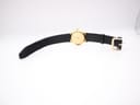 Full view of the Gucci 3000 Jr watch from above, showcasing the black leather strap and gold-plated case.