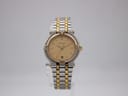 Front view of bi-metal Gucci 9000 L watch with champagne dial and gold-tone bezel on a clear display stand.