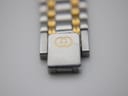 Macro shot of the bi-metal bracelet's fold-over clasp, clearly showing the iconic engraved Gucci interlocking G logo.