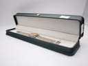 The Gucci 9000 L watch resting neatly inside an open, dark green presentation box with a soft, cream-coloured interior lining.