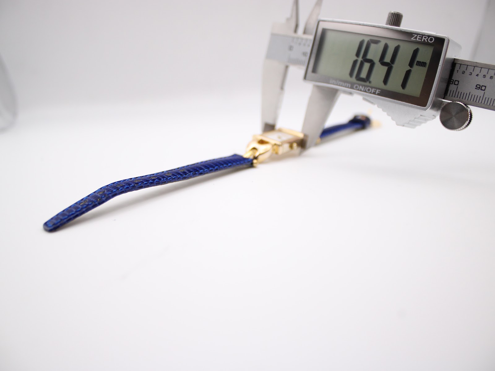 Digital caliper measuring the width of the watch case, displaying a precise measurement of 16.41 mm.