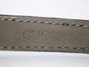 Close-up of the blue leather strap interior showing the embossed 'GUCCI®' logo.