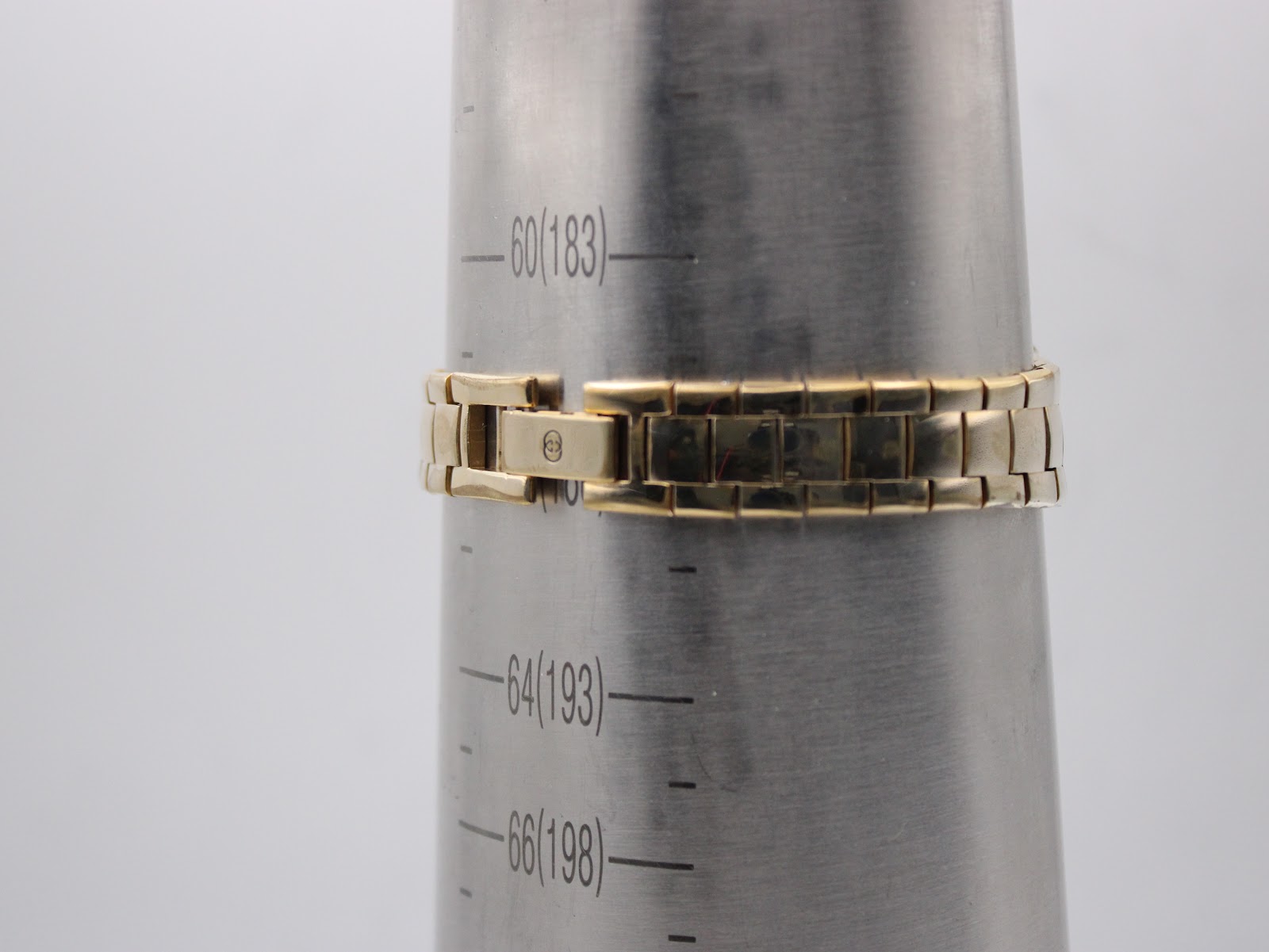 The watch bracelet on a wrist sizing gauge, indicating a maximum wrist circumference of approximately 183mm, with a signed clasp visible.