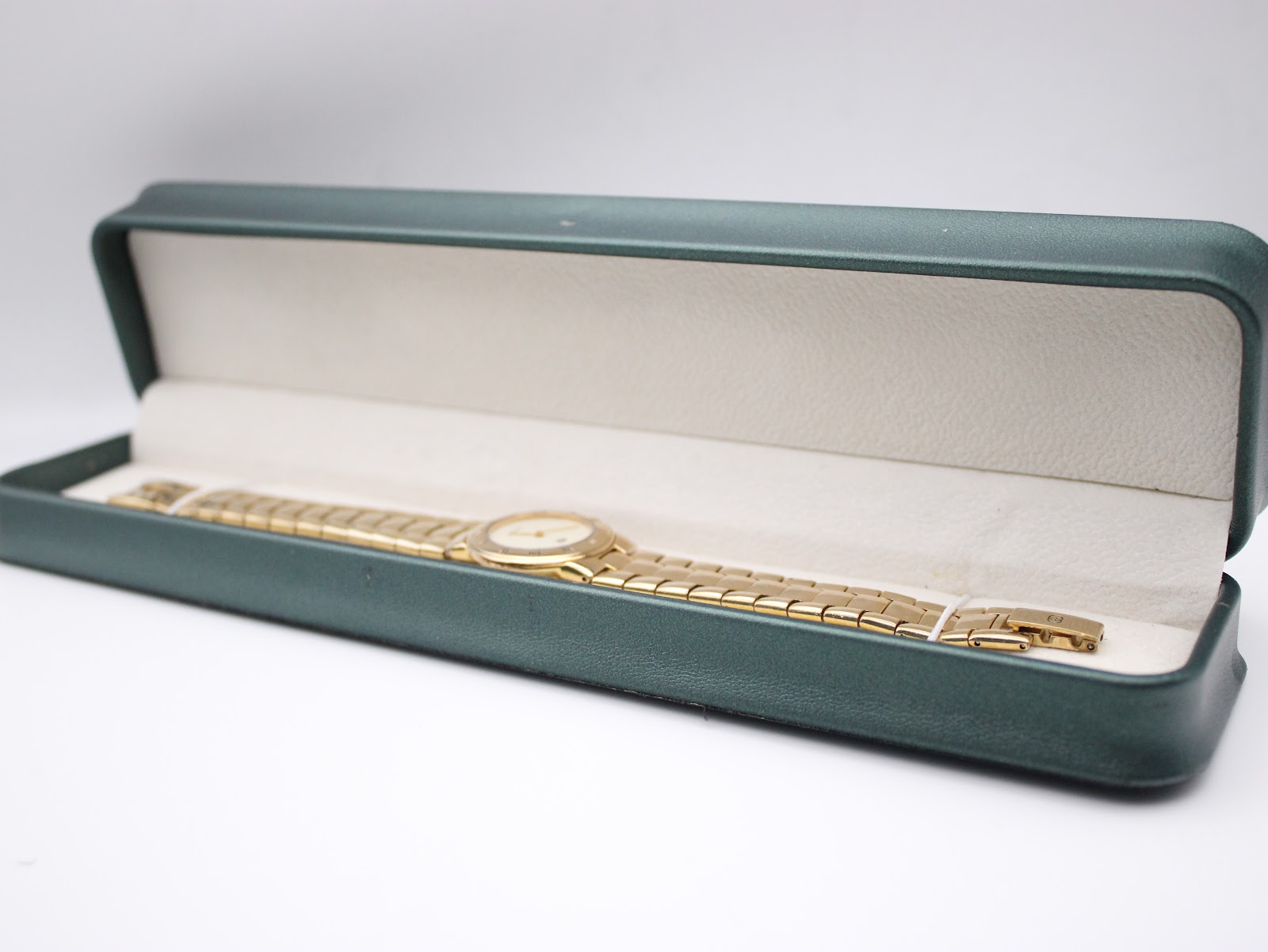 The Gucci 3300L watch neatly placed inside a generic rectangular green presentation box.