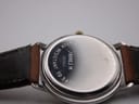 Full length view of the Gucci watch laid flat, showing the brown leather strap and gold-tone buckle.