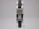 Front view of Gucci 3900L watch with silver GG monogram dial and black leather strap on display stand.