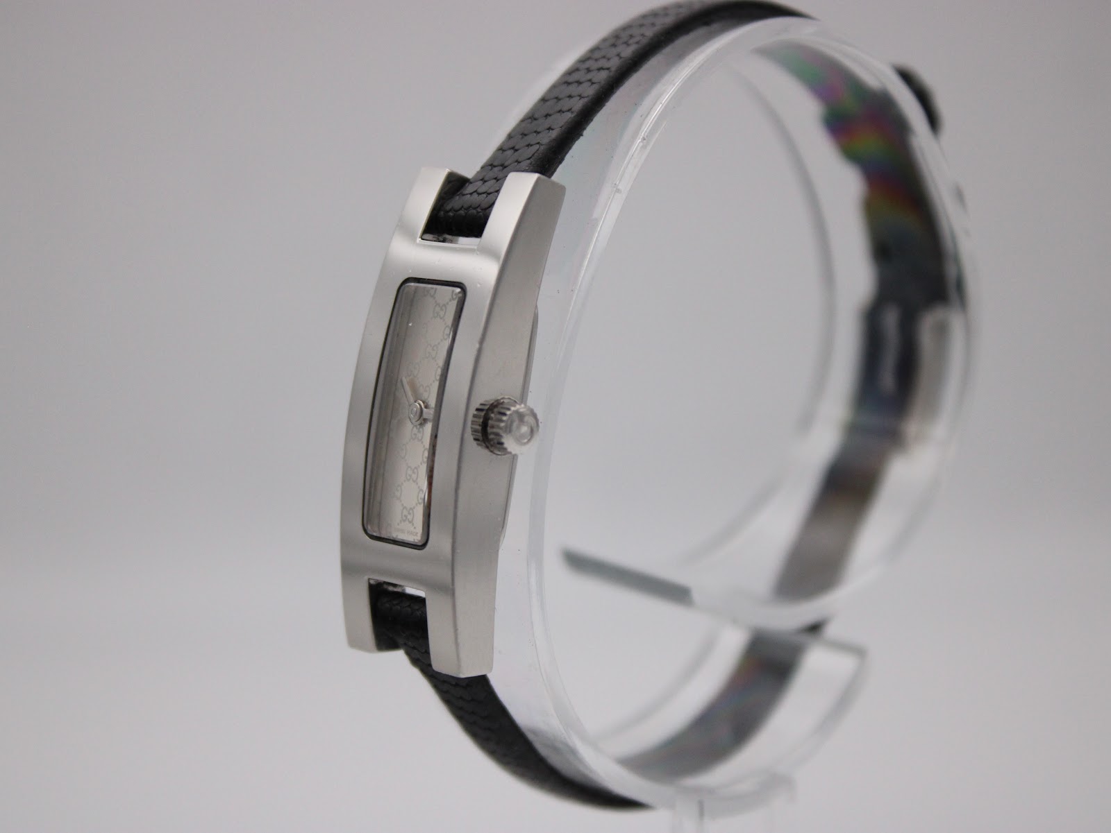 Angled view of Gucci 3900L watch showing side profile, original crown, and black leather strap on display.