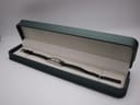 The Gucci 3900L watch presented inside a long, slim green watch box for display.