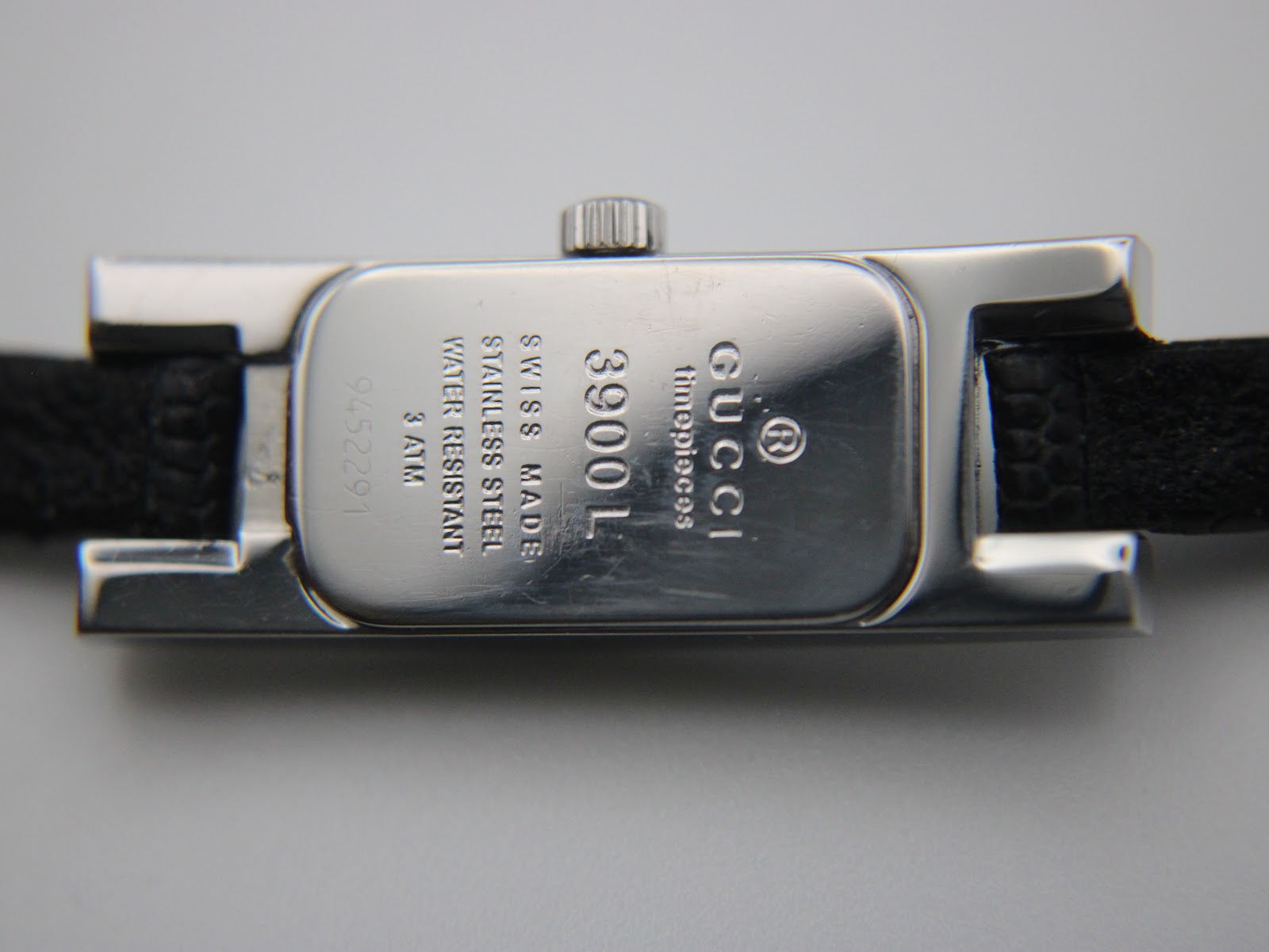 Close-up of the polished stainless steel case back with Gucci branding, model 3900L, serial number, and water resistance engraved.