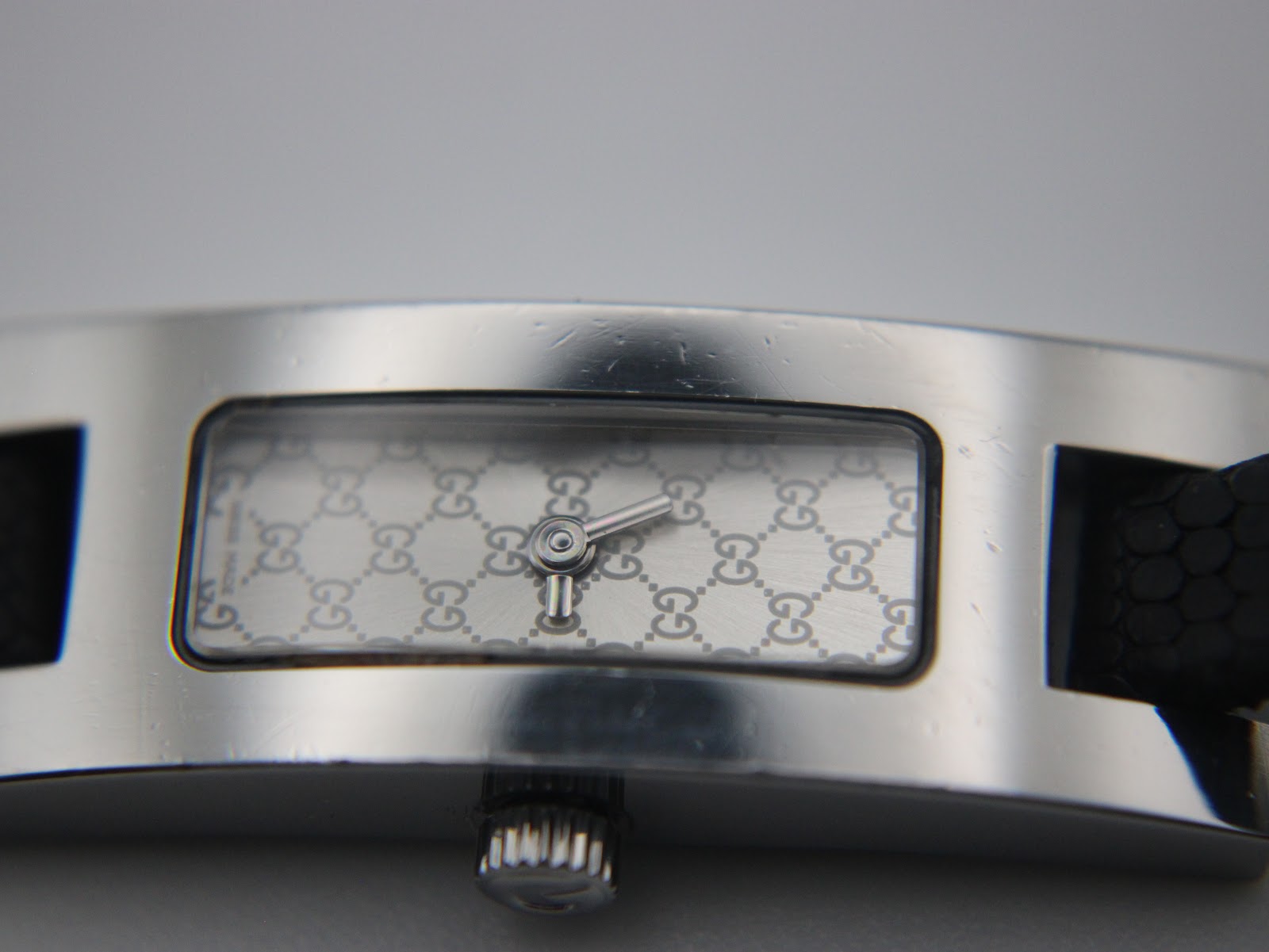 Detailed close-up of the silver-tone dial with the iconic Gucci GG monogram pattern and silver hands.