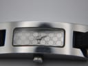 Detailed close-up of the silver-tone dial with the iconic Gucci GG monogram pattern and silver hands.