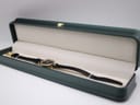 Gucci 2000L watch with black leather strap displayed inside an open green presentation box.