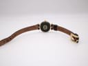 Back view of the Gucci 2000L watch, showing the case back with interlocking G logo and the brown underside of the leather strap.