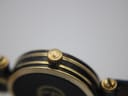 Close-up of the original Gucci signed crown on the gold-tone watch case.