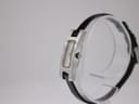 Side-angled view of the Gucci 3900L watch on a clear stand, highlighting the slim profile of the stainless steel case and the original signed crown.