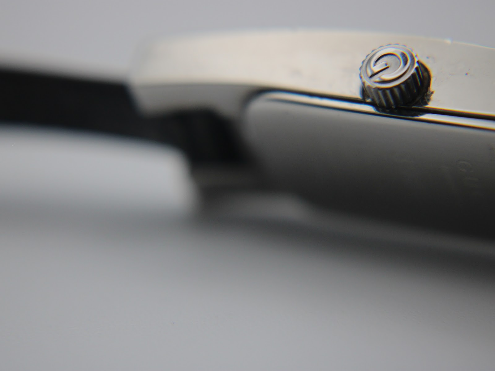 Macro shot of the original Gucci signed crown with its distinctive 'G' logo.