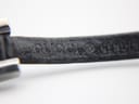 Close-up of the black leather strap showing the debossed "GUCCI" stamp.