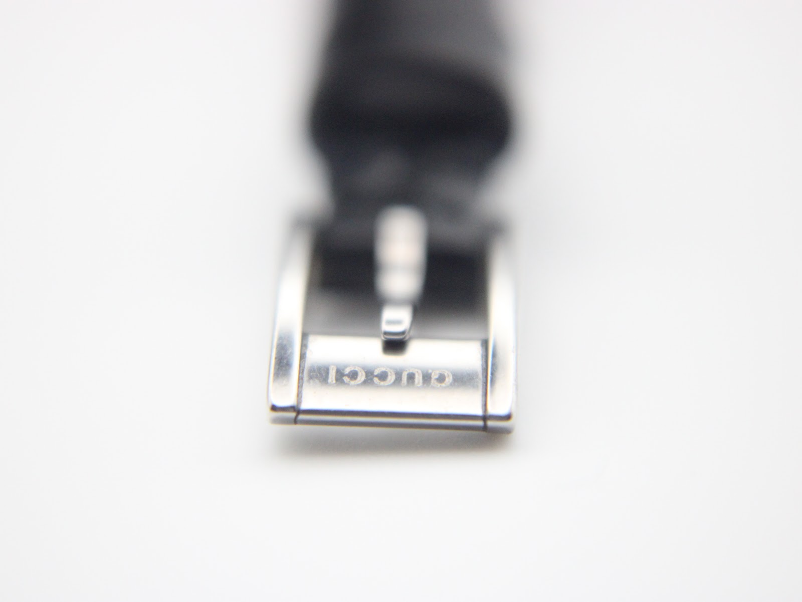 Close-up of the stainless steel buckle, clearly showing the "GUCCI" engraving.