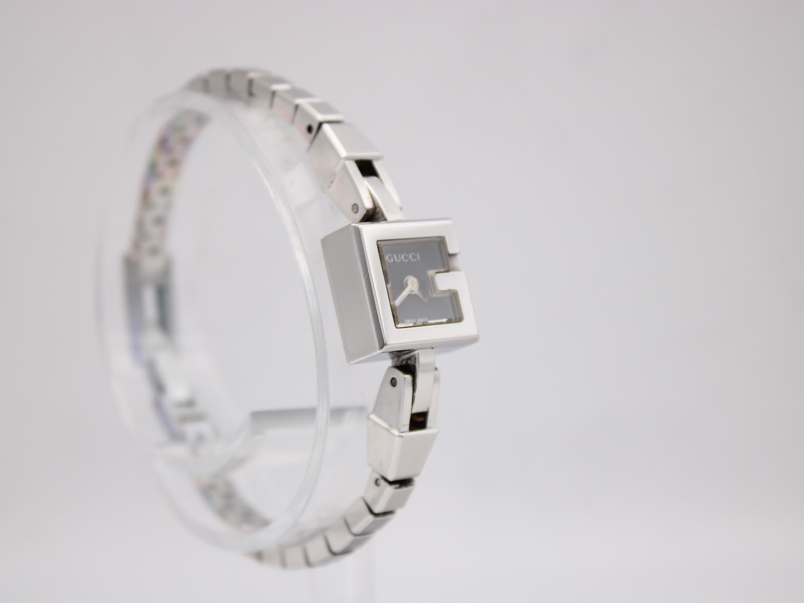 Another angled side view of the Gucci G-Frame watch, highlighting the unique G-shape of the dial and polished case.