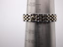 The watch bracelet displayed on a metal wrist sizing gauge, indicating a wrist circumference fit of approximately 155mm.
