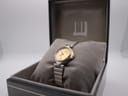 Dunhill watch presented in its original black box with gold trim, resting on a grey cushion.