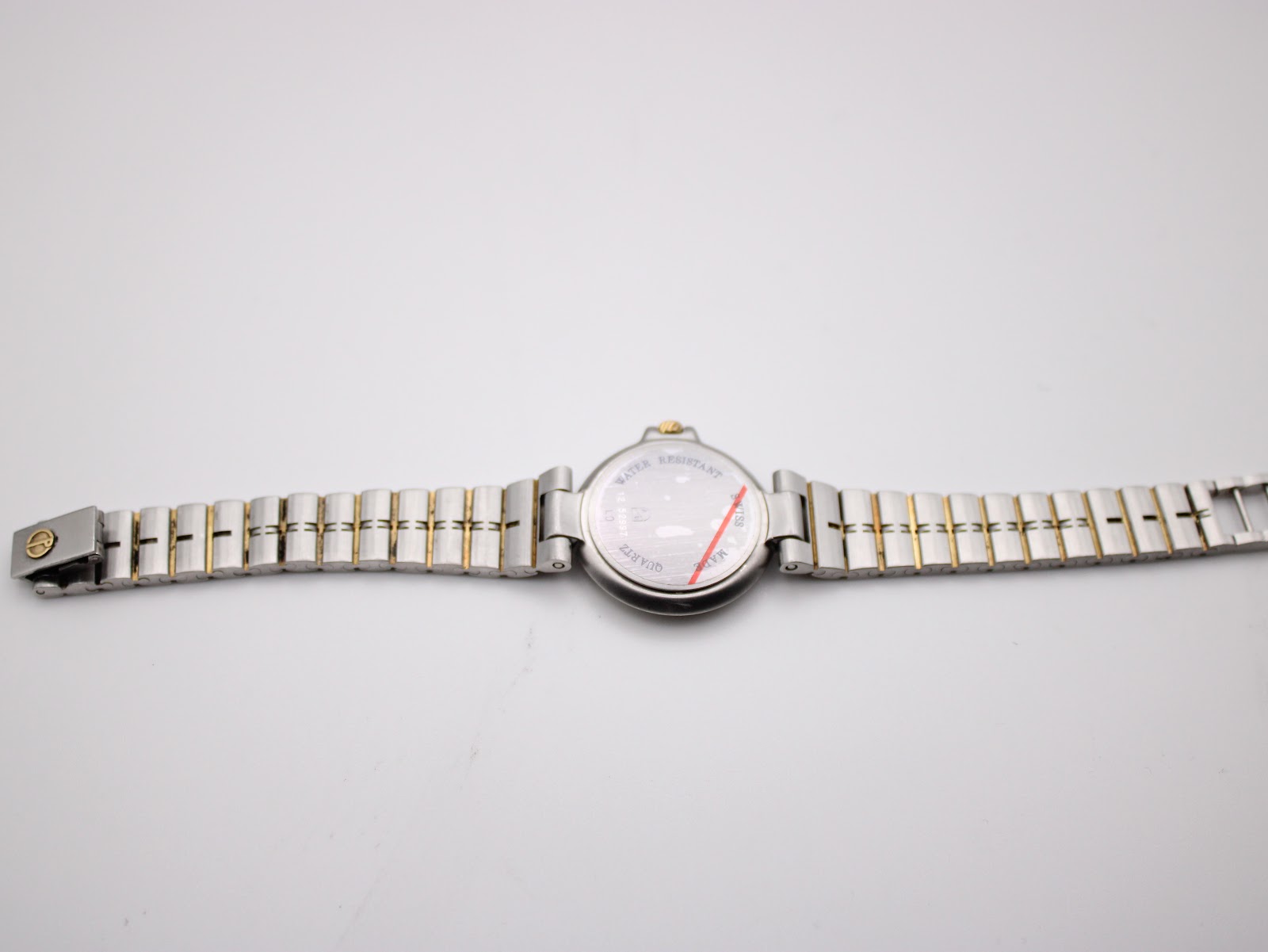 Dunhill watch with two-tone bracelet laid flat, showing the case back.